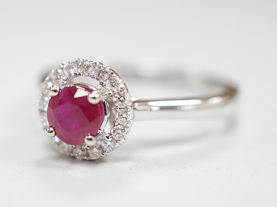 A modern 18ct white gold, ruby and diamond set circular cluster ring, size M, gross weight 3.1 grams.